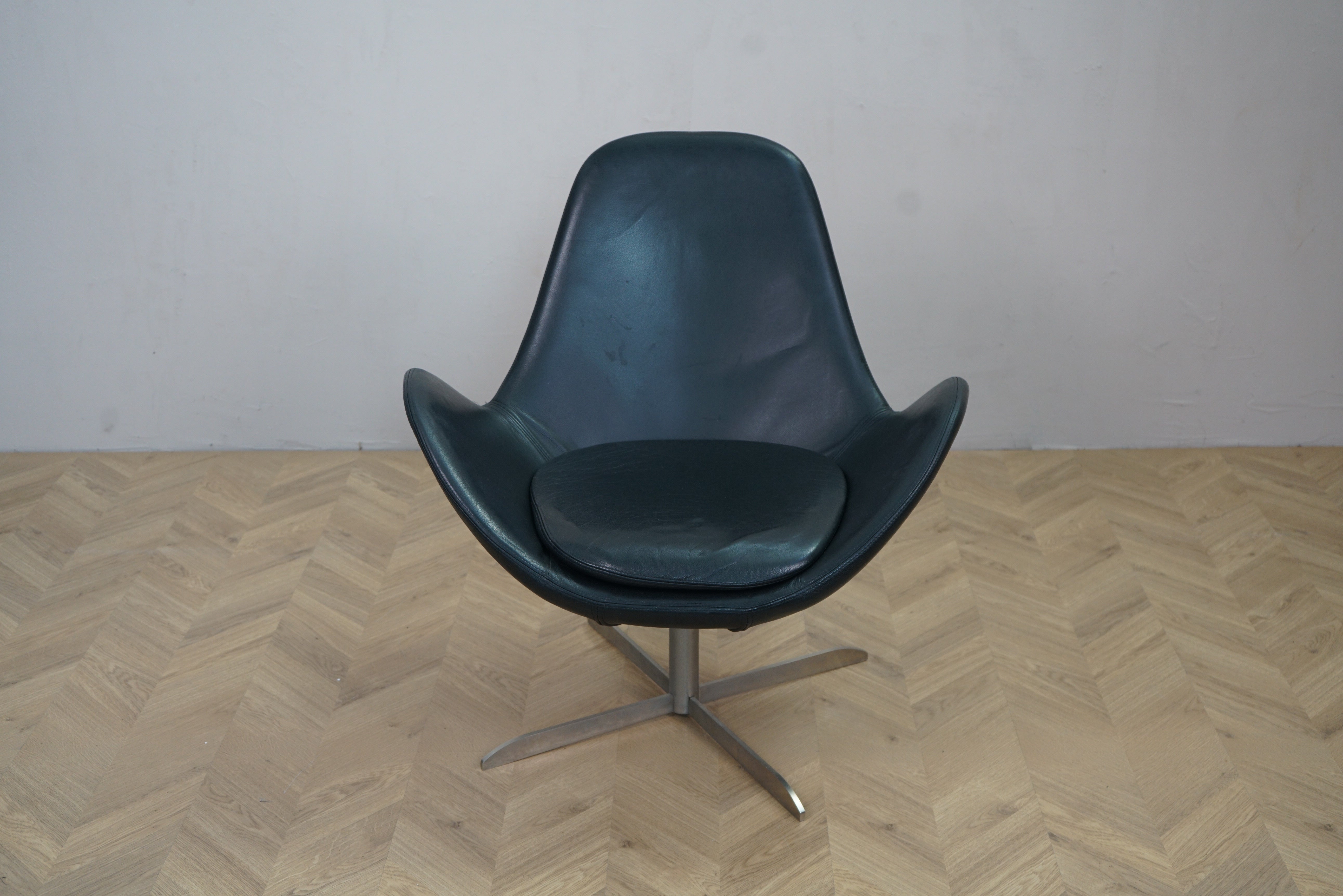 Lænestol i sort læder med løs sædehynde og drejefod set forfra